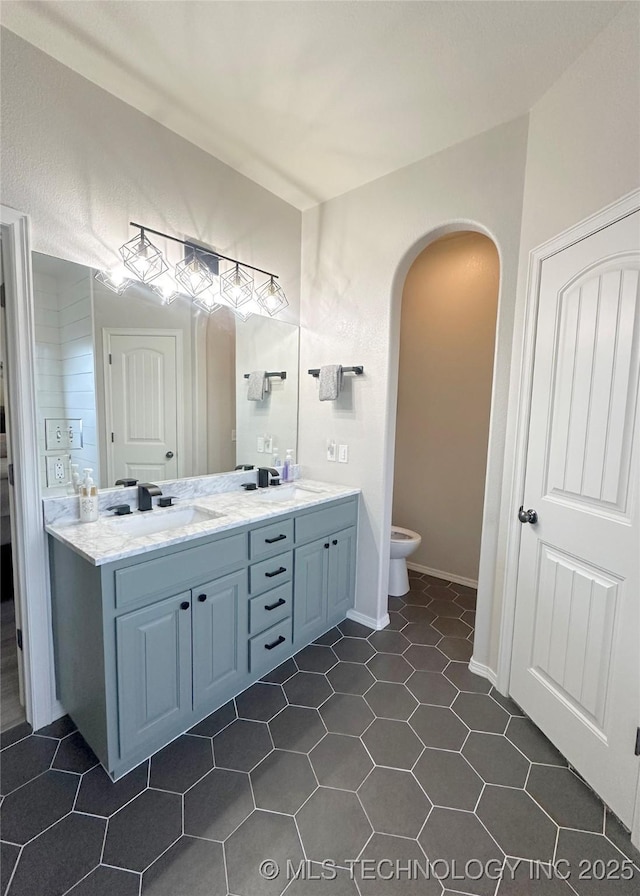 bathroom featuring vanity, tile patterned floors, and toilet