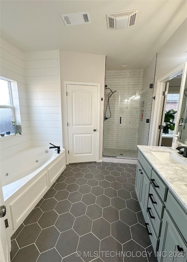 bathroom with independent shower and bath, vanity, and tile patterned floors