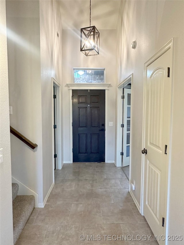 foyer entrance with a chandelier and a high ceiling