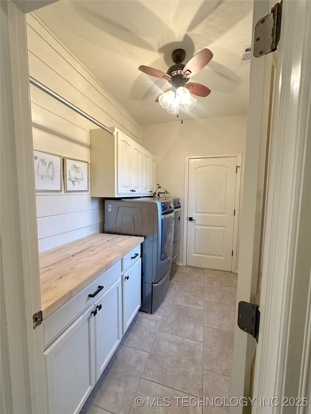 washroom with washer and dryer, cabinets, ceiling fan, and light tile patterned flooring