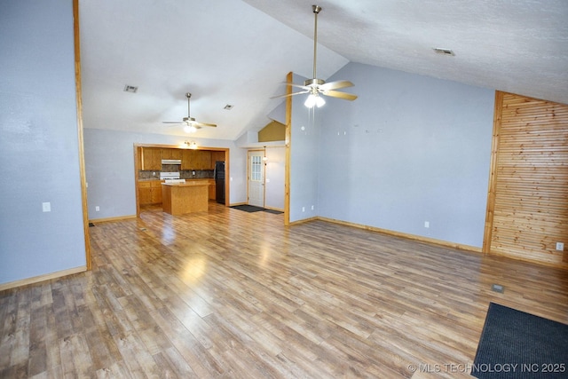 unfurnished living room with lofted ceiling, ceiling fan, and light hardwood / wood-style flooring