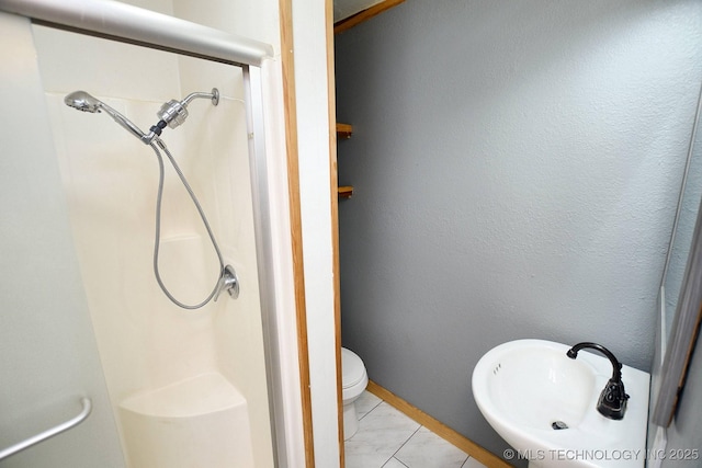 bathroom featuring a shower, sink, and toilet