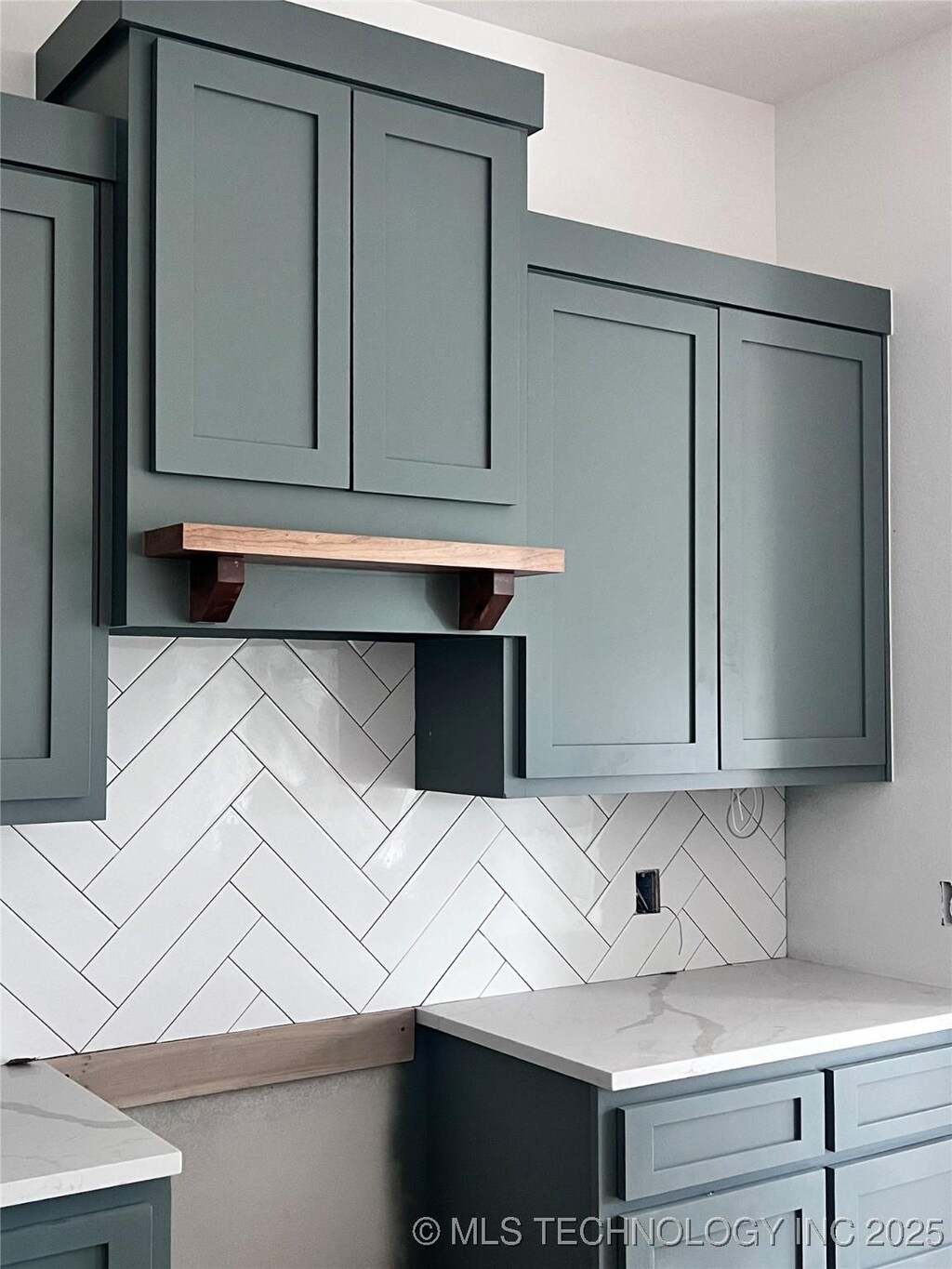 kitchen featuring light stone countertops and backsplash