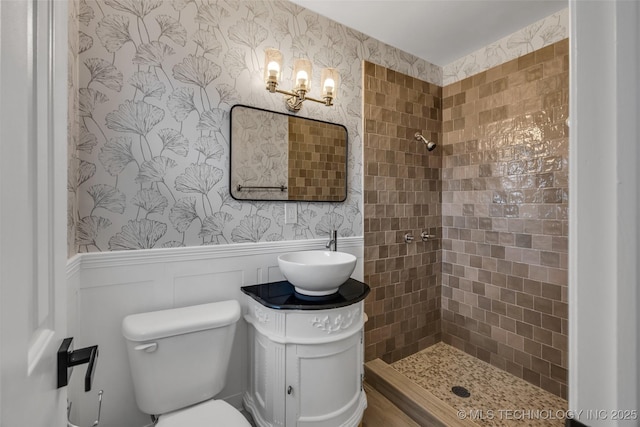 bathroom featuring vanity, tiled shower, and toilet