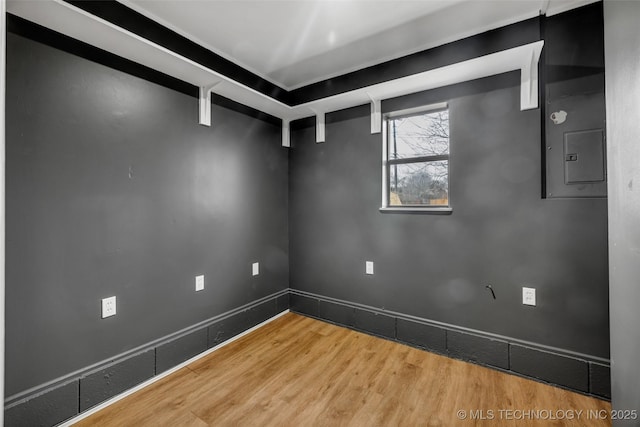 empty room with hardwood / wood-style flooring and electric panel