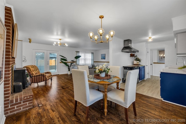 dining space with an inviting chandelier, dark hardwood / wood-style floors, sink, and french doors