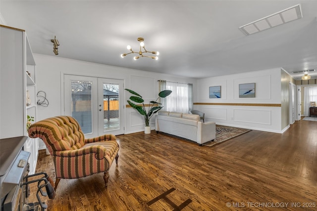 living room featuring hardwood / wood-style floors, an inviting chandelier, and french doors