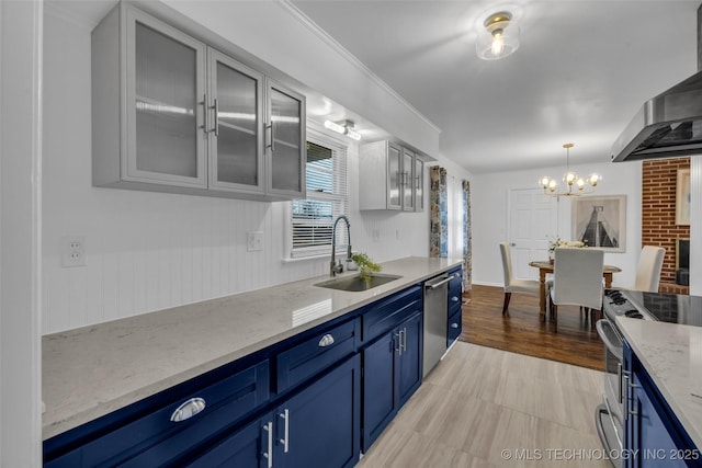 kitchen with sink, blue cabinetry, stainless steel appliances, light stone counters, and wall chimney exhaust hood