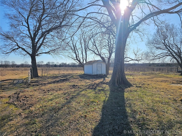 view of yard featuring a rural view and a storage unit