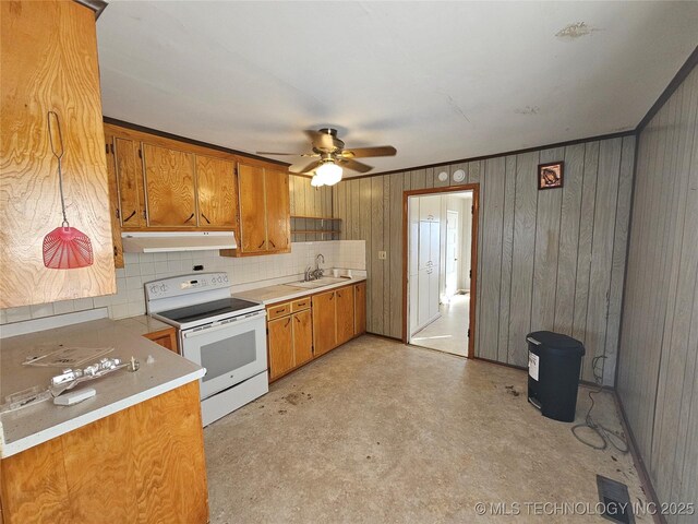 kitchen featuring wooden walls, sink, decorative backsplash, electric range, and ceiling fan