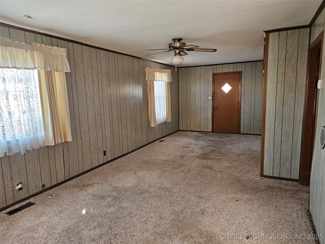 carpeted entryway featuring crown molding, ceiling fan, and a wealth of natural light