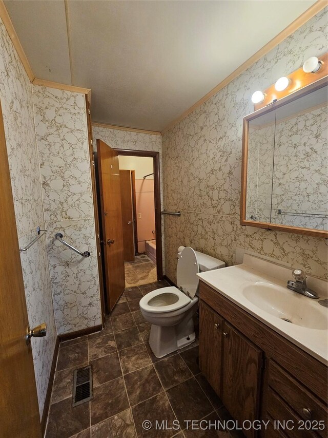 bathroom with ornamental molding, toilet, and vanity