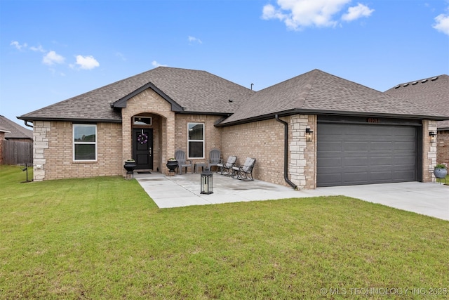 french country inspired facade featuring a garage, a patio area, and a front lawn