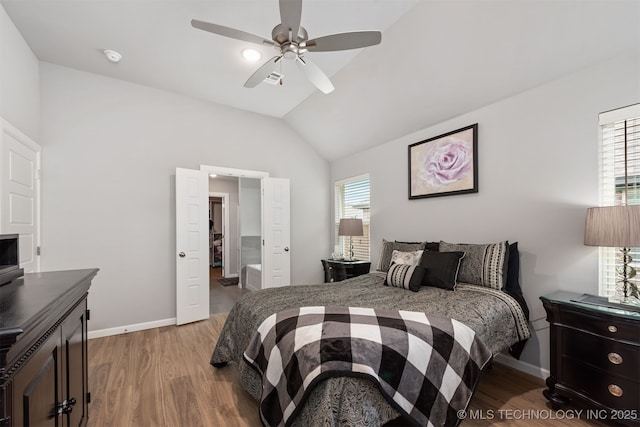 bedroom with hardwood / wood-style flooring, vaulted ceiling, and ceiling fan