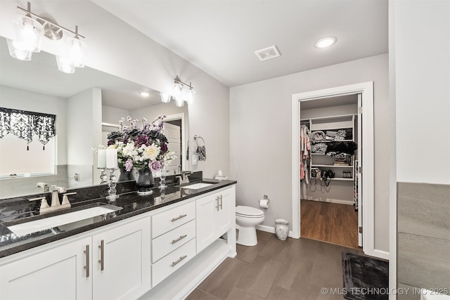 bathroom featuring vanity, hardwood / wood-style flooring, and toilet