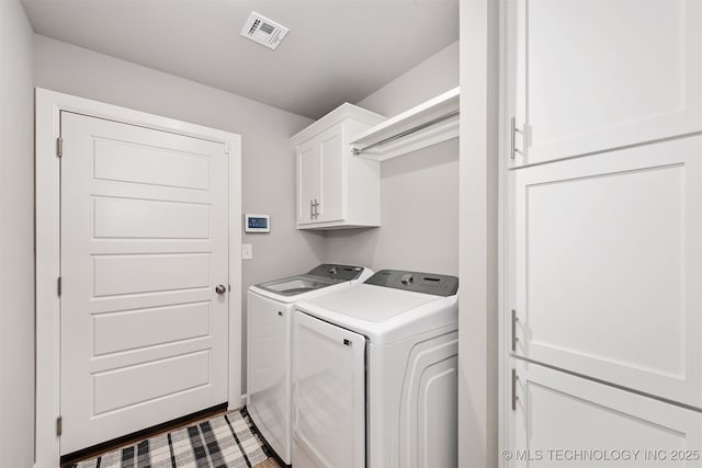 laundry area with separate washer and dryer and cabinets