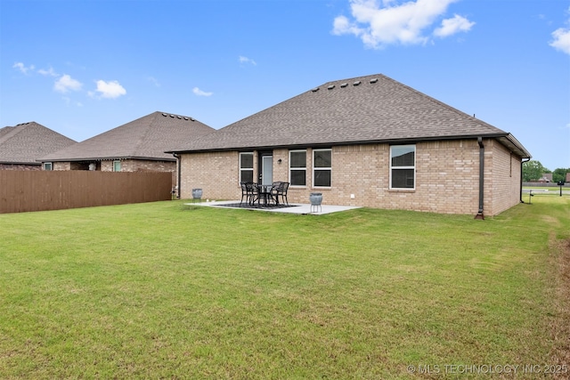 back of property with a yard and a patio area