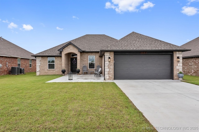 view of front of property with a garage, a front lawn, and central air condition unit