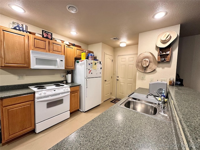 kitchen with sink, a textured ceiling, and white appliances