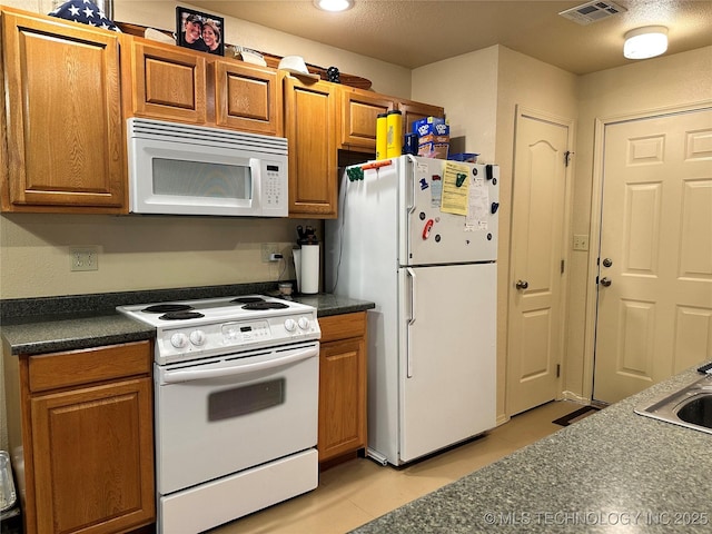 kitchen featuring a textured ceiling and white appliances