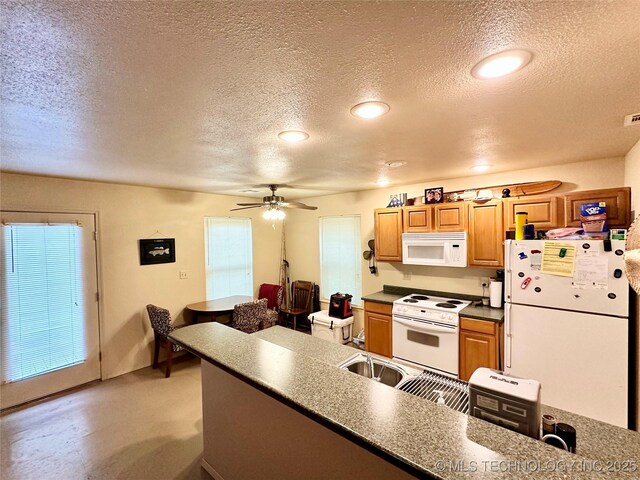 kitchen featuring ceiling fan, white appliances, plenty of natural light, and a textured ceiling