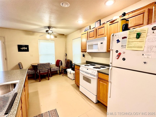 kitchen with ceiling fan, white appliances, sink, and a textured ceiling