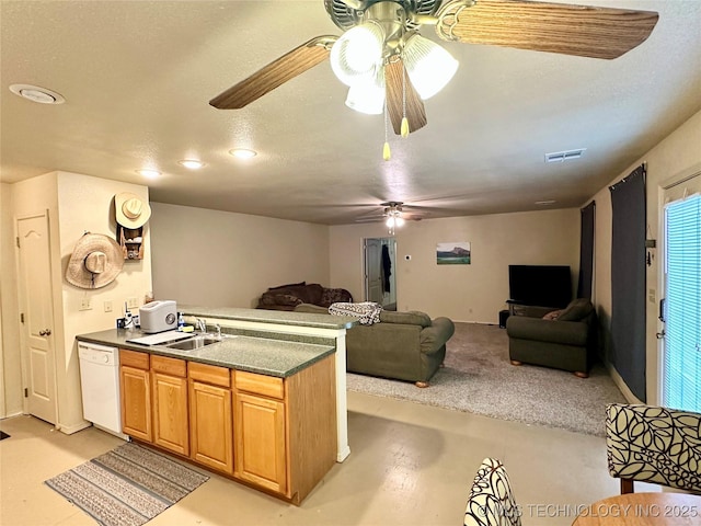 kitchen featuring sink, a textured ceiling, ceiling fan, white dishwasher, and light colored carpet