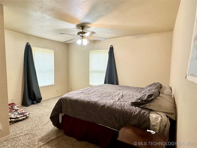 bedroom with ceiling fan, carpet flooring, and a textured ceiling