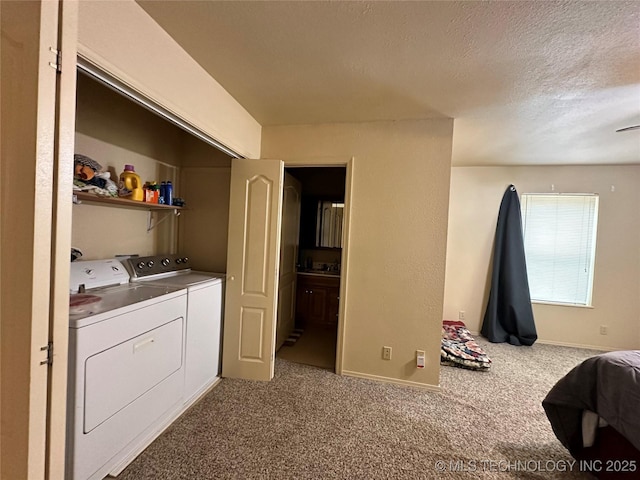 laundry area with carpet floors, washer and clothes dryer, and a textured ceiling