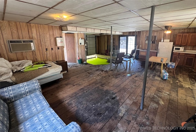 interior space with a paneled ceiling, wood-type flooring, a wall unit AC, and wood walls