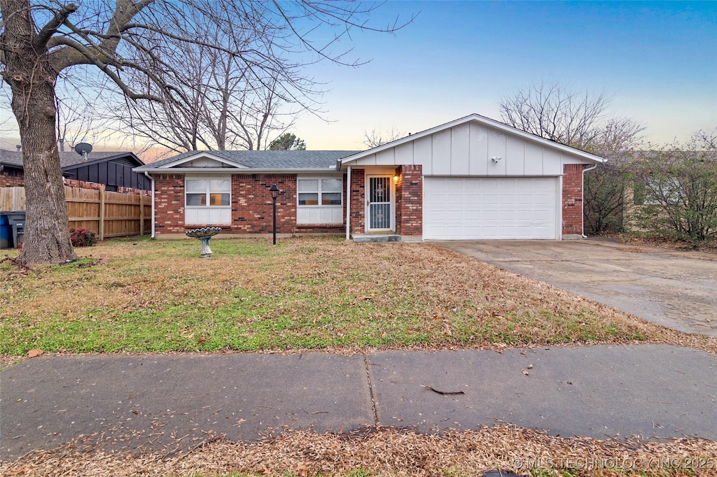 single story home featuring a garage and a lawn