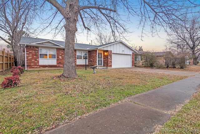 single story home with a garage and a lawn