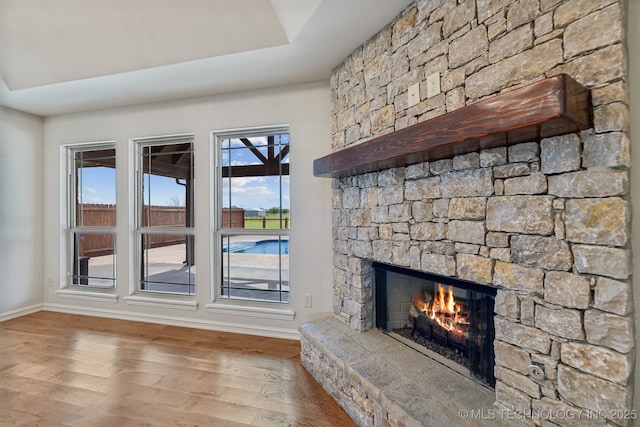 unfurnished living room featuring a stone fireplace and light hardwood / wood-style floors