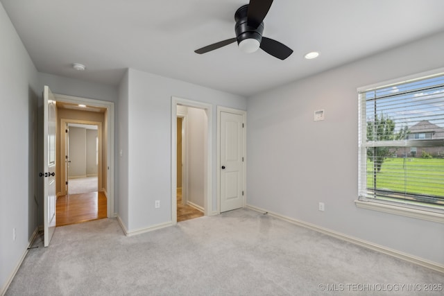 unfurnished bedroom with light colored carpet and ceiling fan