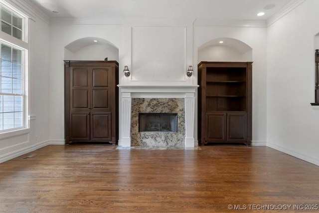 unfurnished living room featuring dark hardwood / wood-style flooring, a fireplace, and ornamental molding