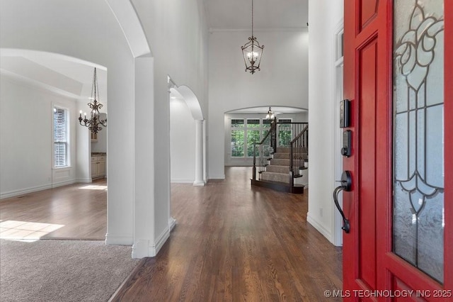 foyer with an inviting chandelier, dark wood-type flooring, and a wealth of natural light