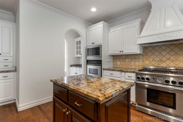 kitchen featuring appliances with stainless steel finishes, dark hardwood / wood-style floors, a kitchen island, white cabinetry, and custom exhaust hood