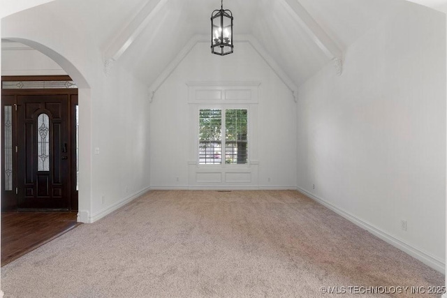 foyer featuring an inviting chandelier, light colored carpet, and vaulted ceiling