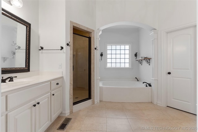 bathroom featuring independent shower and bath, vanity, and tile patterned flooring