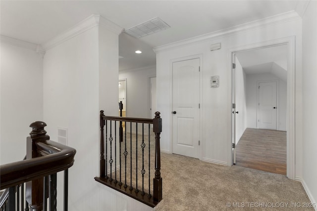 corridor featuring crown molding and light carpet