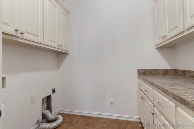 laundry room with cabinets, hookup for an electric dryer, and dark tile patterned flooring