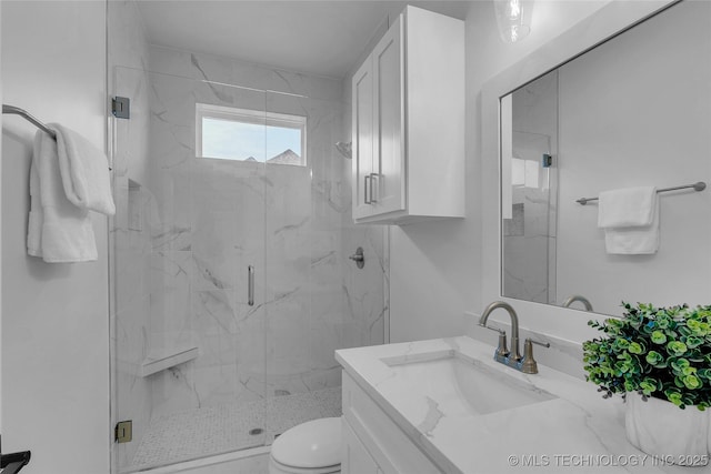 bathroom with vanity, a shower with shower door, and toilet