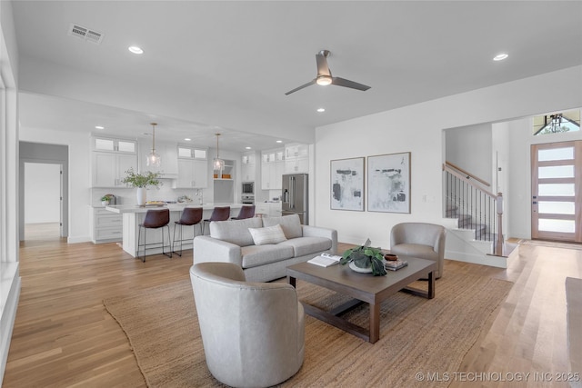 living room with ceiling fan and light wood-type flooring