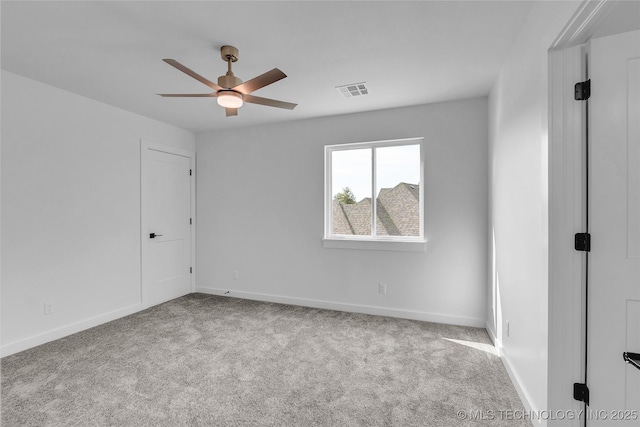 spare room featuring light colored carpet and ceiling fan