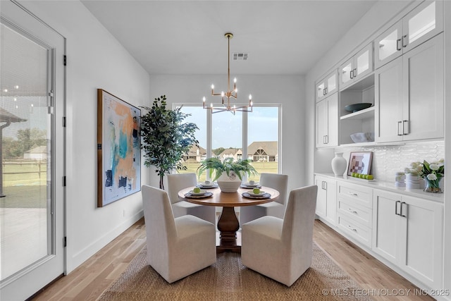 dining space featuring an inviting chandelier and light hardwood / wood-style flooring