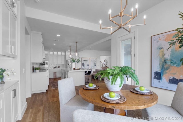 dining space featuring dark hardwood / wood-style floors, sink, and a notable chandelier