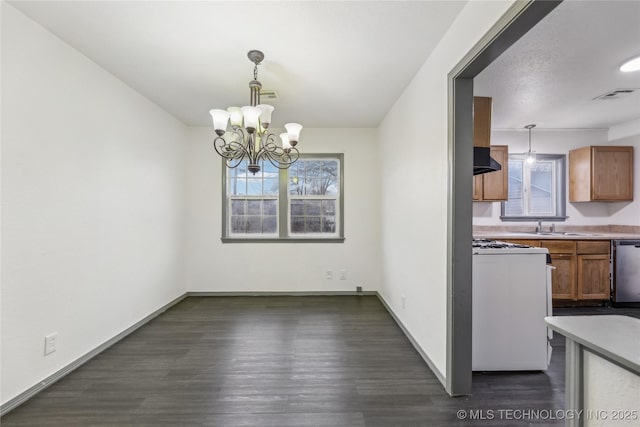 unfurnished dining area featuring an inviting chandelier, a wealth of natural light, and dark hardwood / wood-style floors