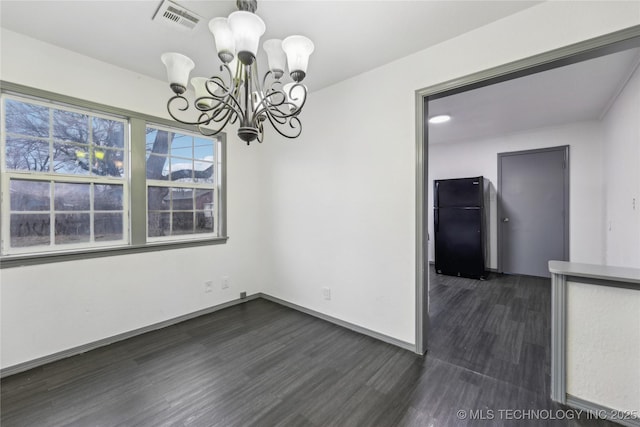 unfurnished dining area with an inviting chandelier and dark hardwood / wood-style floors