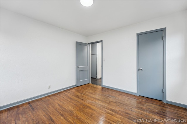 unfurnished bedroom with dark wood-type flooring