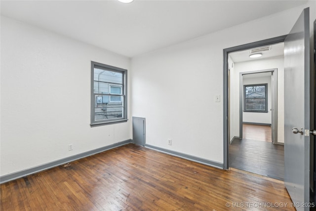 empty room with dark hardwood / wood-style flooring